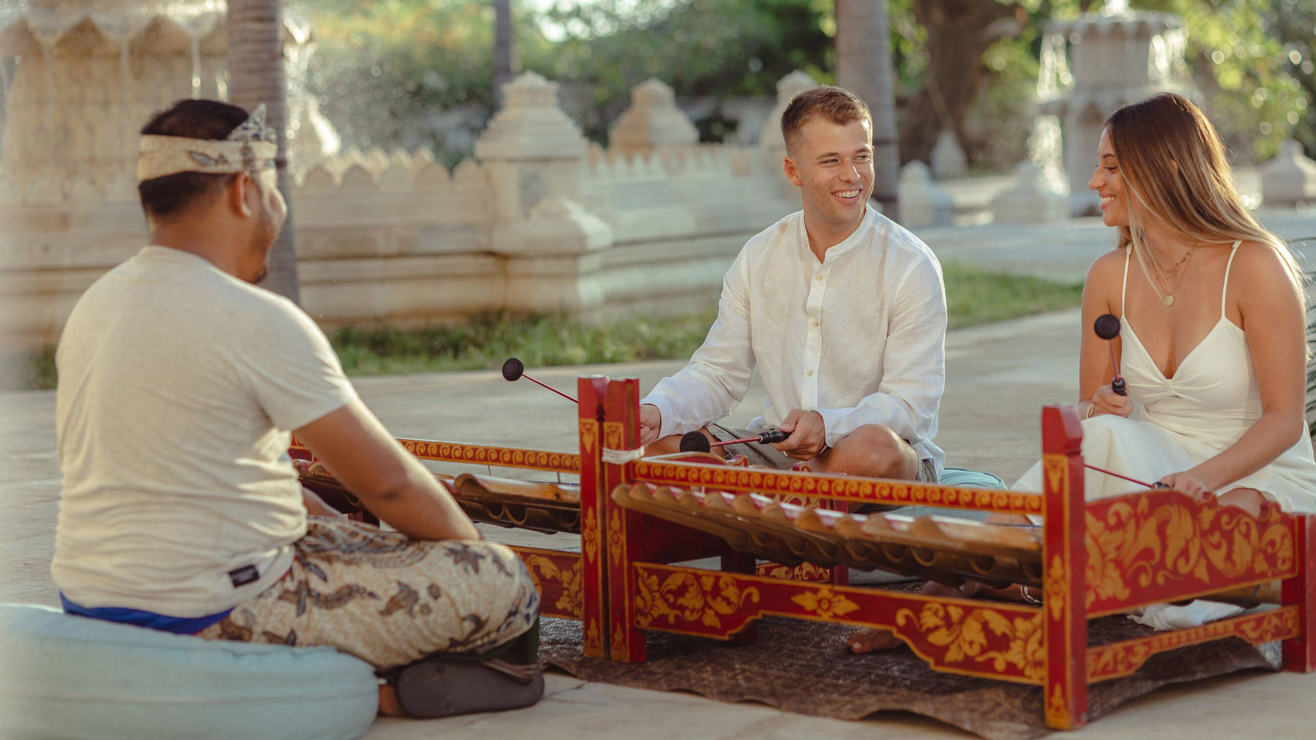 Couple taking part in a Rindik music class at Jumeirah Bali