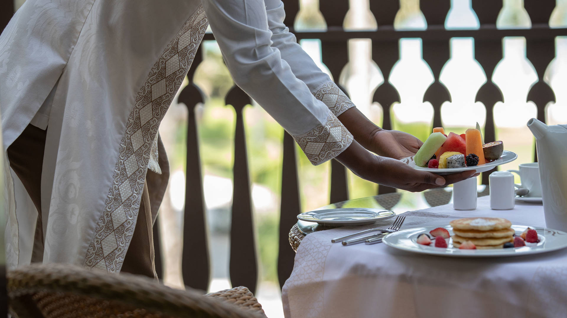 Frau serviert Frühstück im Hotel Jumeirah Dar Al Masyaf