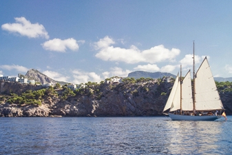 Sailboat on the sea against mountain backdrop